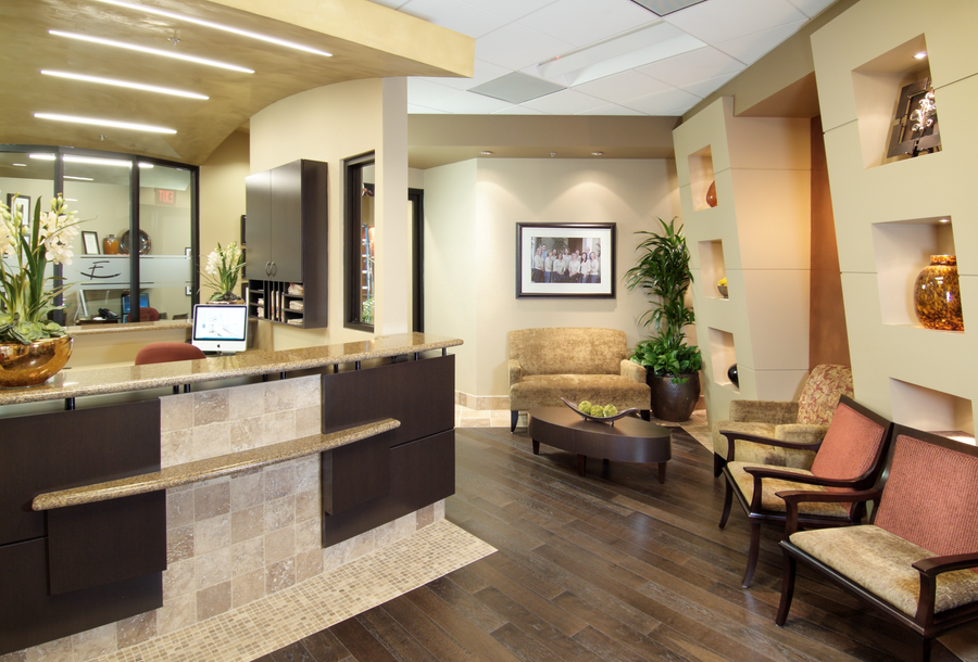 The reception and waiting area, with a warm reception desk, a loveseat, and armchairs arranged like a living room.